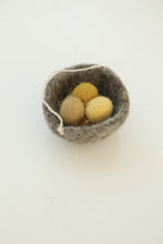 grey felt basket with ochre eggs inside