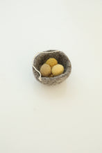 grey felt basket with ochre eggs inside